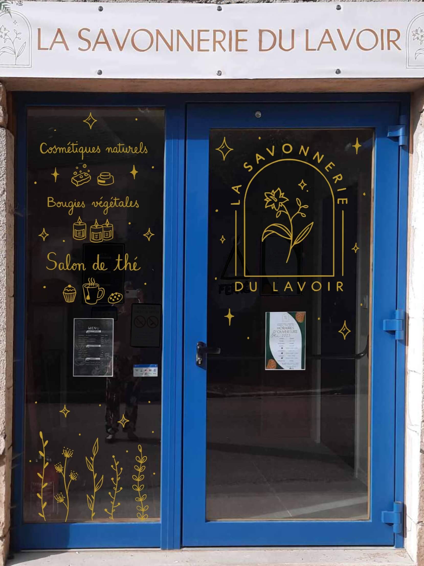 Peinture sur vitrine pour la porte d'entrée d'une savonnerie artisanale dans le Morvan près de Vezelay? Peinture acrylique dorée avec éléments végétaux et logo du magasin.